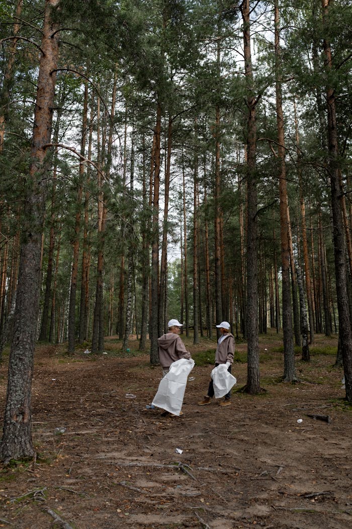 hero-contact Two volunteers cleaning up litter in a forest park, promoting environmental conservation.